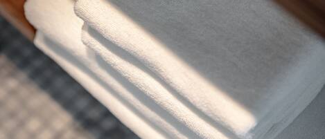 Primer plano de una toalla blanca apilada sobre una superficie de madera.
