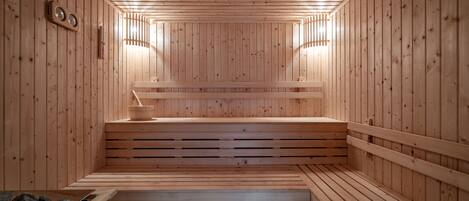 A wooden sauna with benches and a stone basin.