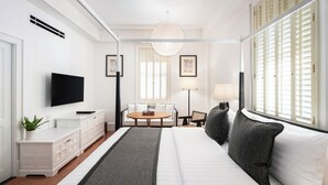 Une chambre d’hôtel moderne équipée d’un lit, d’une télévision, d’un bureau et d’une chaise.