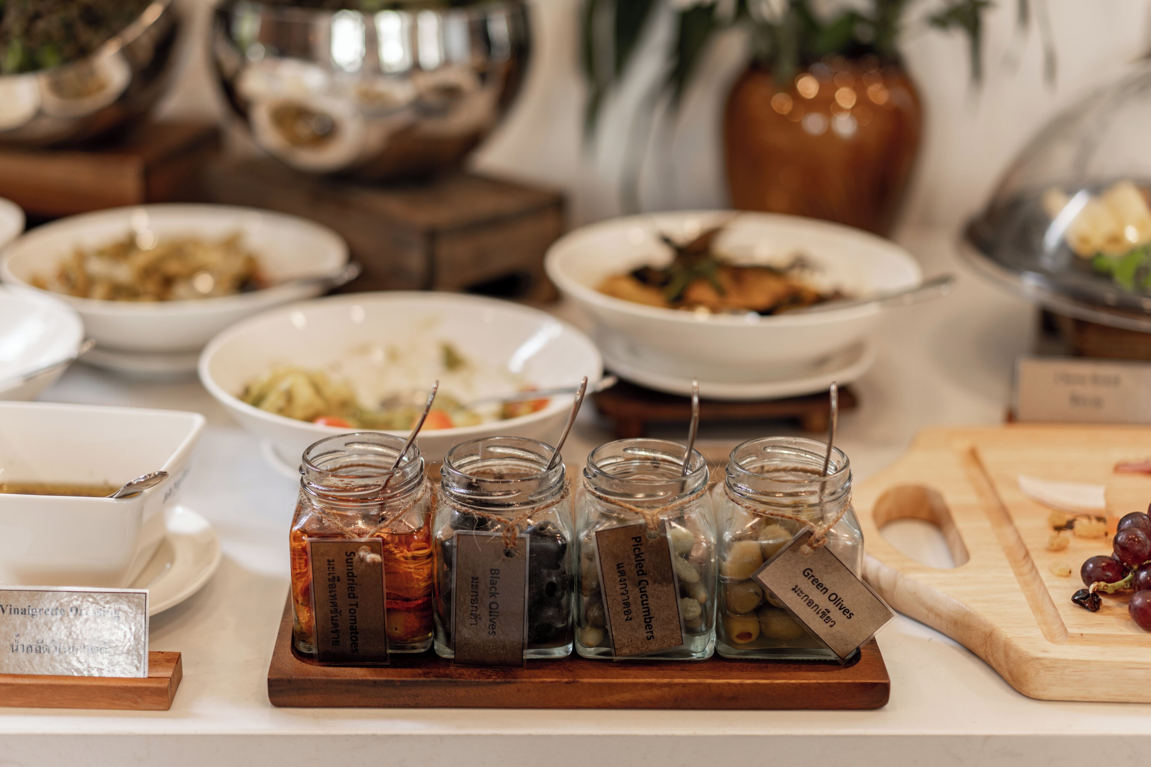 Een buffet met diverse gerechten en potten ingelegde groenten.