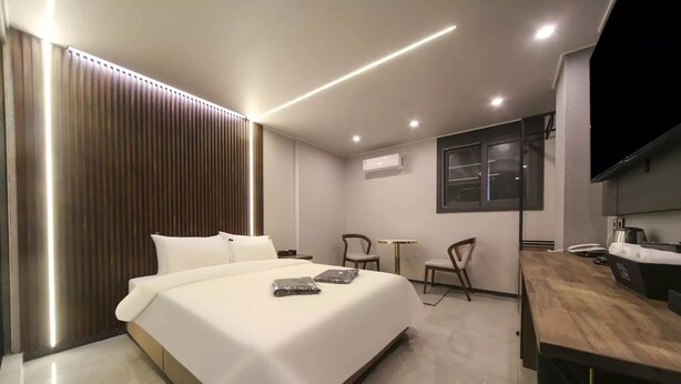 Een moderne hotelkamer met een groot bed, een bureau, een stoel en een televisie.