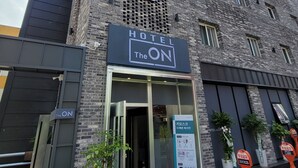Een modern hotel met een opvallend bord waarop 'HOTEL The ON' staat.