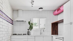 Una cocina moderna con armarios blancos, una estufa a gas, un lavamanos y un ventanal con vistas.