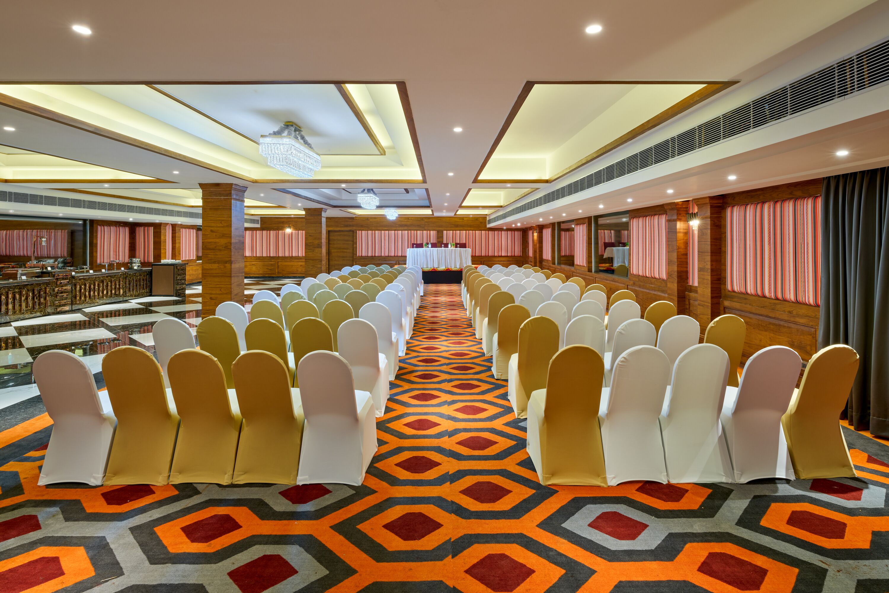 Un salón de conferencias con filas de sillas y un escenario.