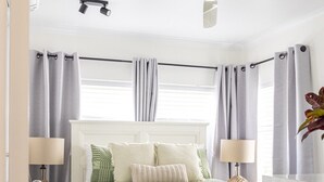 A bedroom with a bed, nightstands, a ceiling fan, and curtains. - BeachLuxe @ Sunseeker, Sublime Tropical Apartment (Port Douglas)
