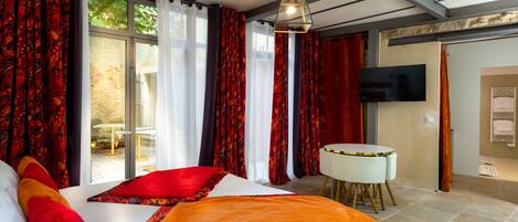Une chambre d’hôtel avec un lit, une télévision et une vue sur l’extérieur.
