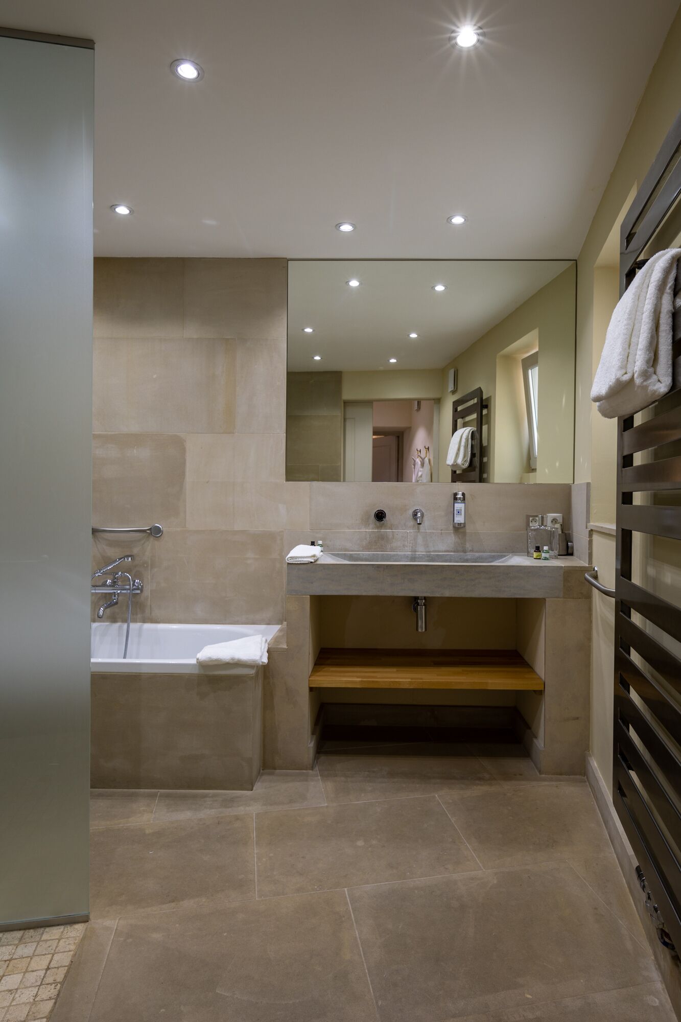 Une salle de bain moderne avec une baignoire, un lavabo et un miroir.