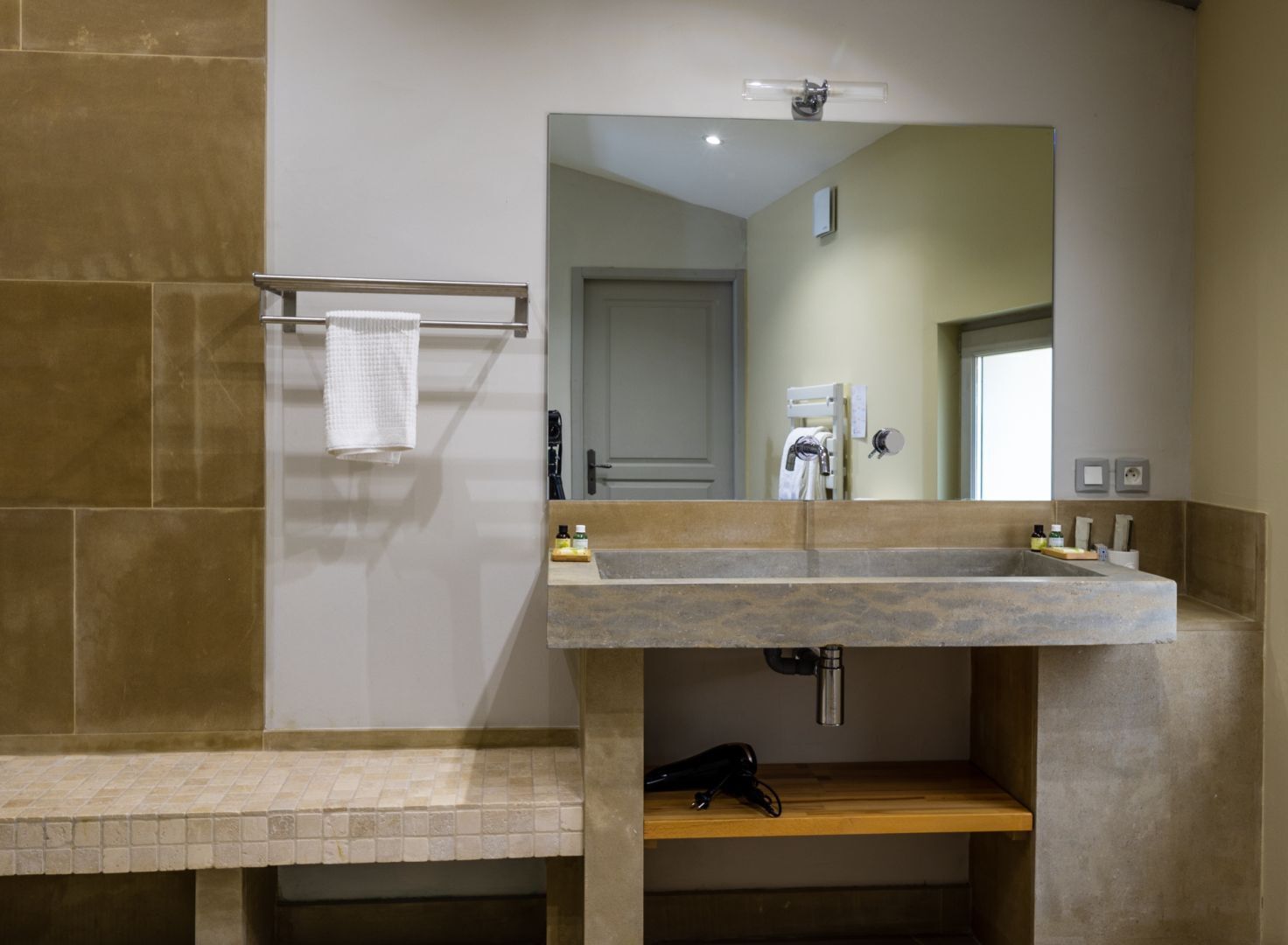 Un baño con un lavabo de piedra, un perchero y un espejo.
