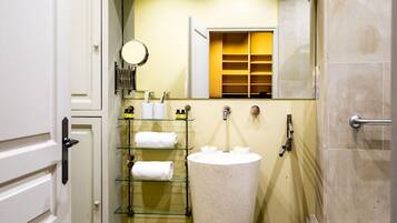 A bathroom with a freestanding sink, a mirror, and a towel rack.