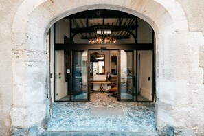An arched doorway leading into a room with a chandelier, a desk, and a chair. - Le Clos Violette D'Aglaé (L'Isle-sur-la-Sorgue)