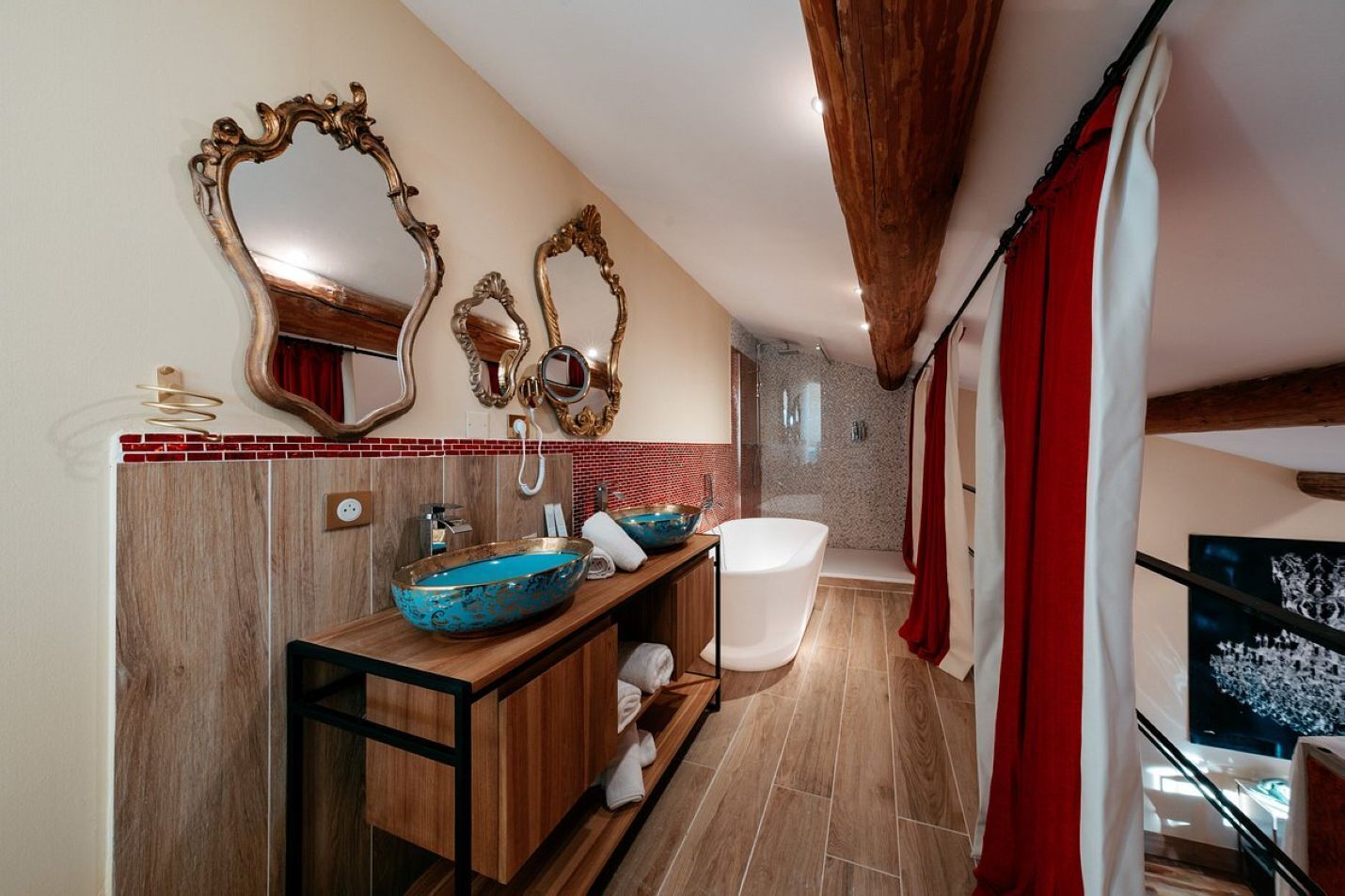 Un baño moderno con tocador de madera, dos espejos grandes, una bañera independiente y una zona de ducha.