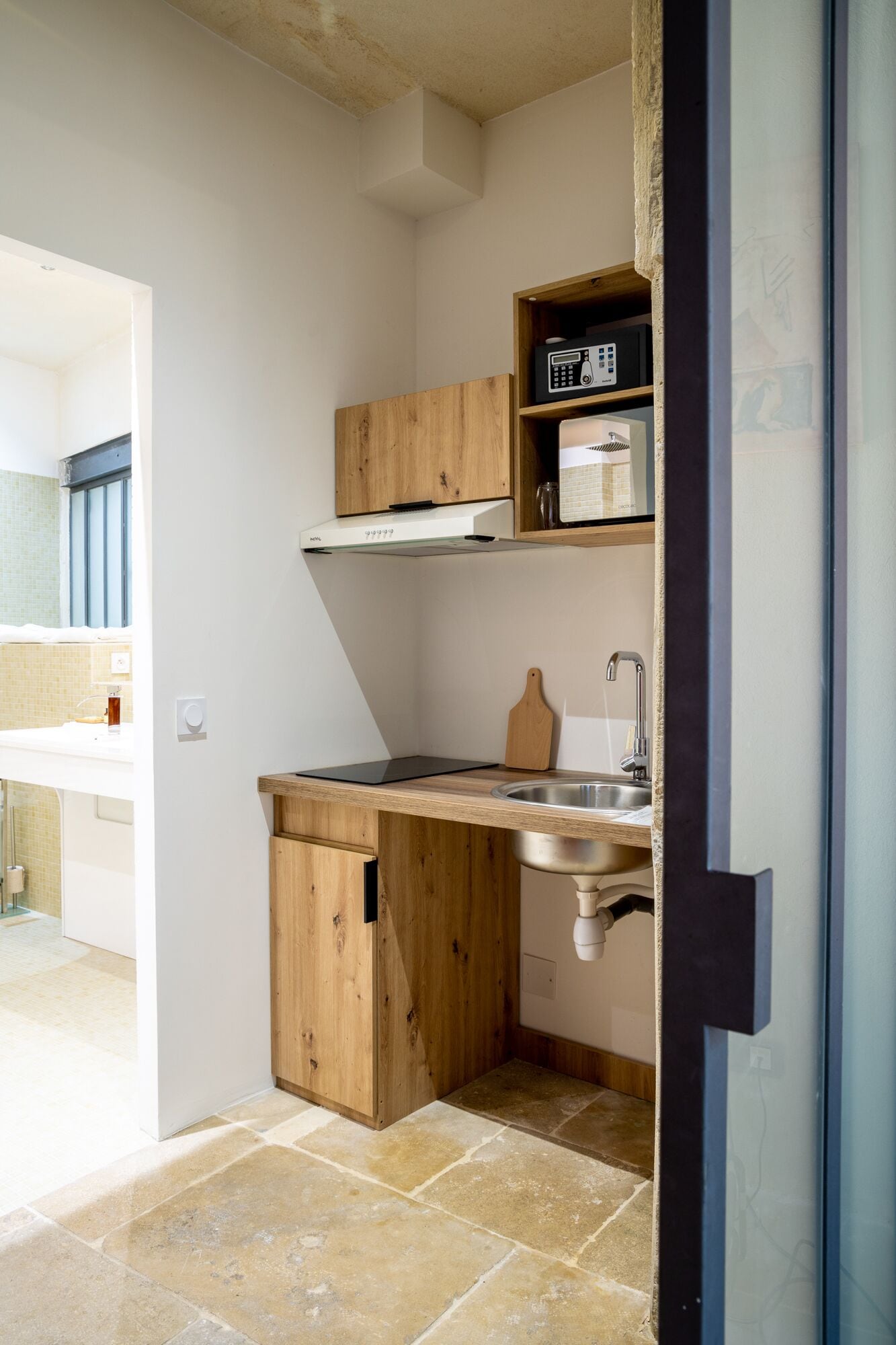 A compact kitchen with a wooden countertop, a built-in stove, and a sink.
