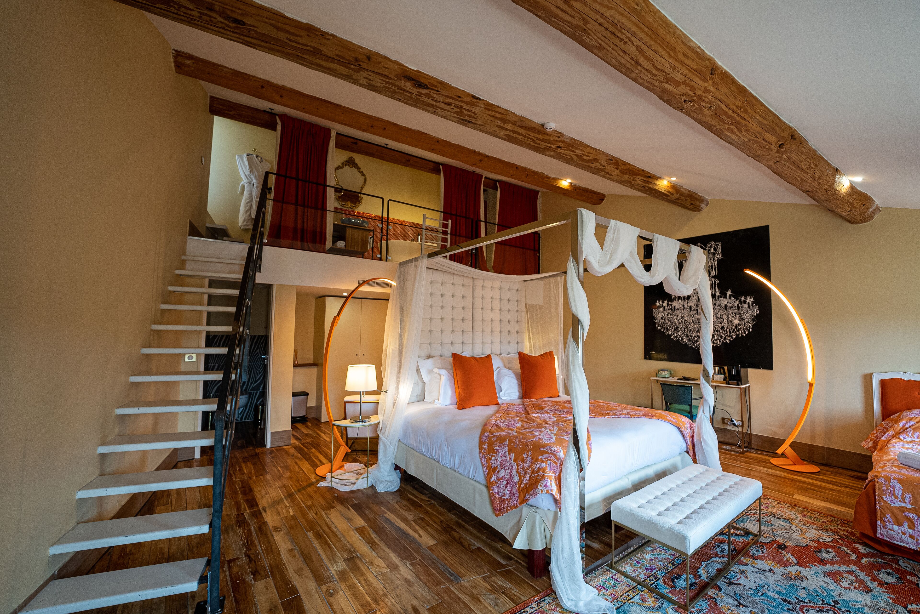 Une chambre à coucher avec un lit à baldaquin, un escalier et un balcon situé au deuxième étage.