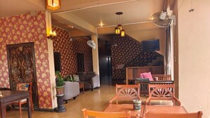 A dining area with wooden furniture and patterned wallpaper. - Wualai Boutique by Lanna Oriental (Chiang Mai)