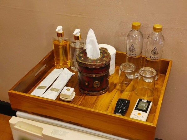 A tray with toiletries including a tissue, hand soap, a small bottle, and two bottles of water. - Wualai Boutique by Lanna Oriental (Chiang Mai)