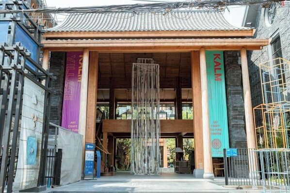 A building entrance with a traditional tiled roof, a vertical banner, and a hanging installation. - Wualai Boutique by Lanna Oriental (Chiang Mai)