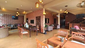 A spacious living area with a dining set, sofas, and a staircase leading to another level. - Wualai Boutique by Lanna Oriental (Chiang Mai)