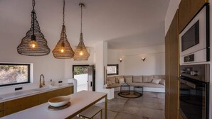 Una cocina moderna con una isla grande, luces colgantes y un horno empotrado.