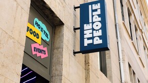 A hostel with a sign indicating it offers food, events, and is managed by The People. - The People Lyon  (Lyon)