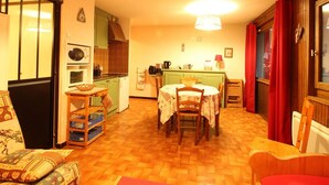 A cozy living room with a dining table, kitchen area, and a sofa. - Studio for 6 people with renovated bathroom and parking, on the slopes (Les Carroz d'Arâches)