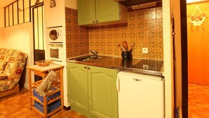 A compact kitchen with green cabinets, a white refrigerator, and a microwave. - Studio for 6 people with renovated bathroom and parking, on the slopes (Les Carroz d'Arâches)