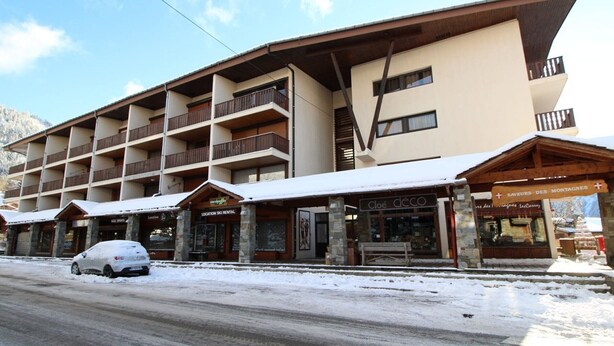 Un hôtel à plusieurs étages doté de balcons, proposant un service de location de matériel de ski et abritant un restaurant appelé « Cloé déco ».