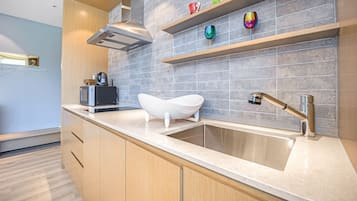 Una cocina moderna con un lavamanos integrado, una bañera blanca y una cafetera.