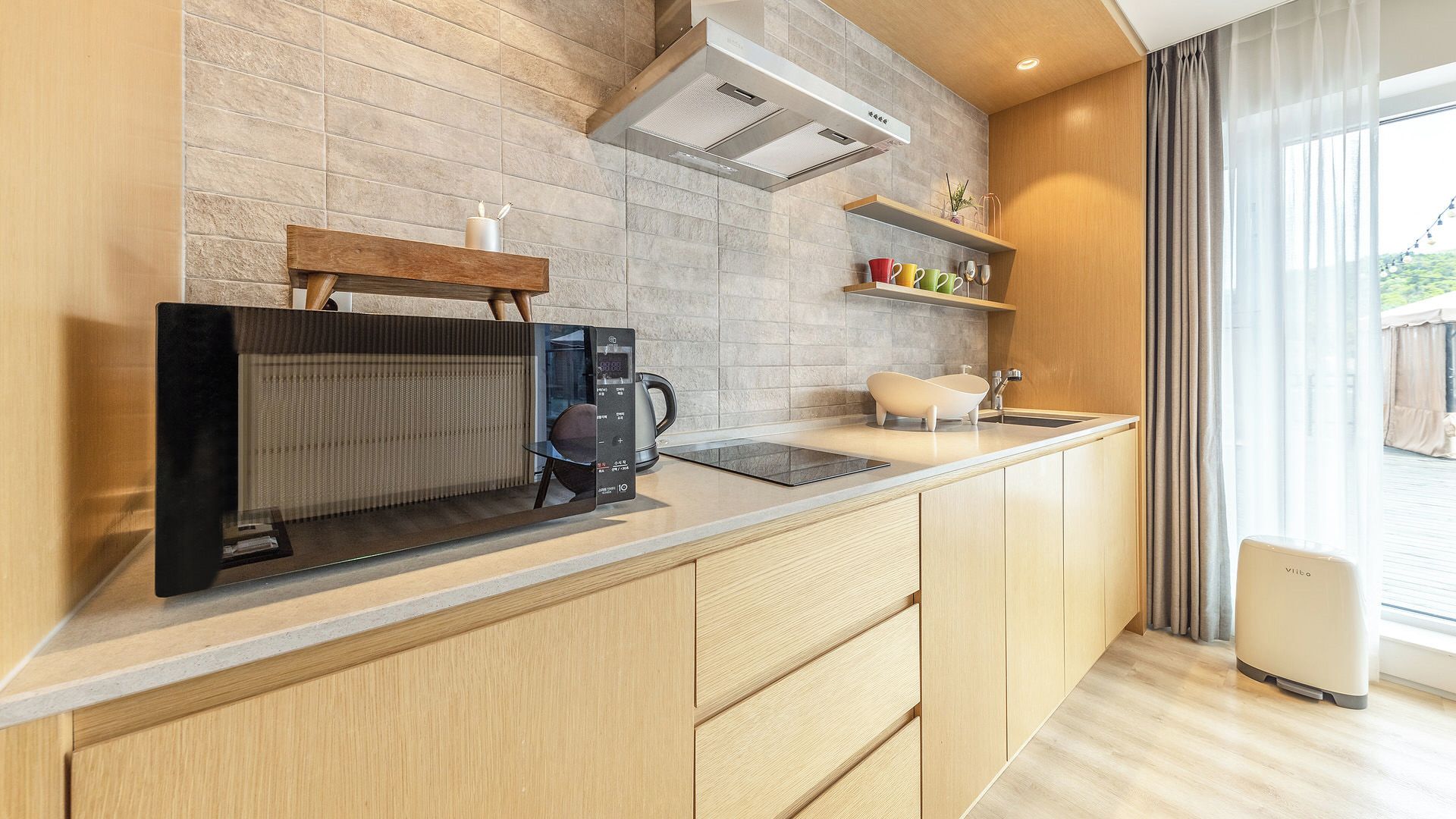 Eine moderne Küche mit integrierter Kaffeemaschine, Wasserkocher und Spüle.