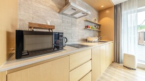 A modern kitchen with a built-in coffee maker, a kettle, and a sink. - Gapyeong Laputa Resort (Gapyeong)