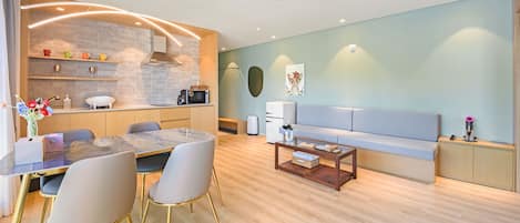 A modern living room with a dining area, a sofa, and a kitchen with a microwave.