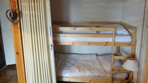 Kerrossängyllä varustettu huone, jonka ovessa on sydämenmuotoinen koriste.