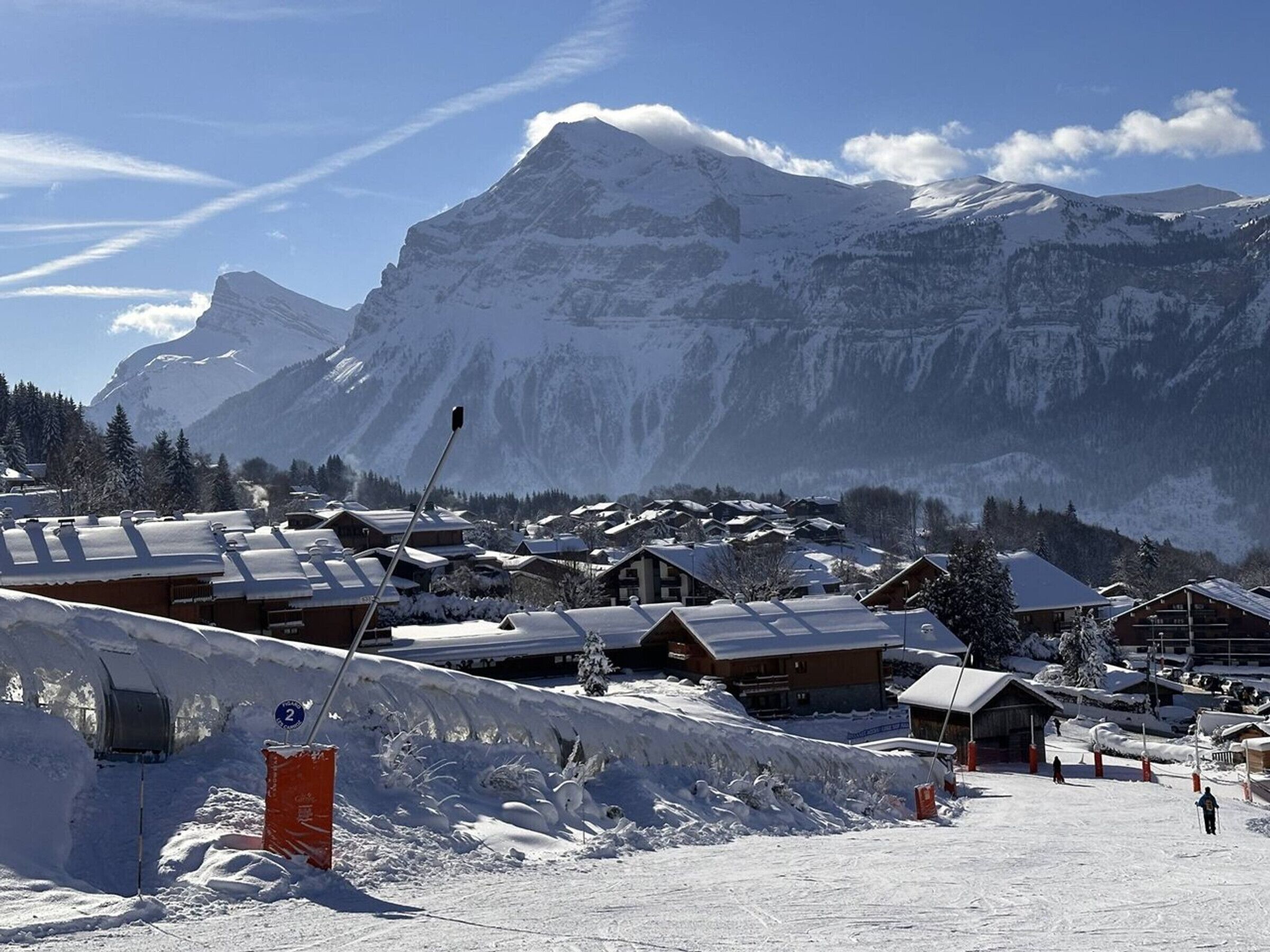 A snow-covered mountain village with wooden buildings and a clear sky.