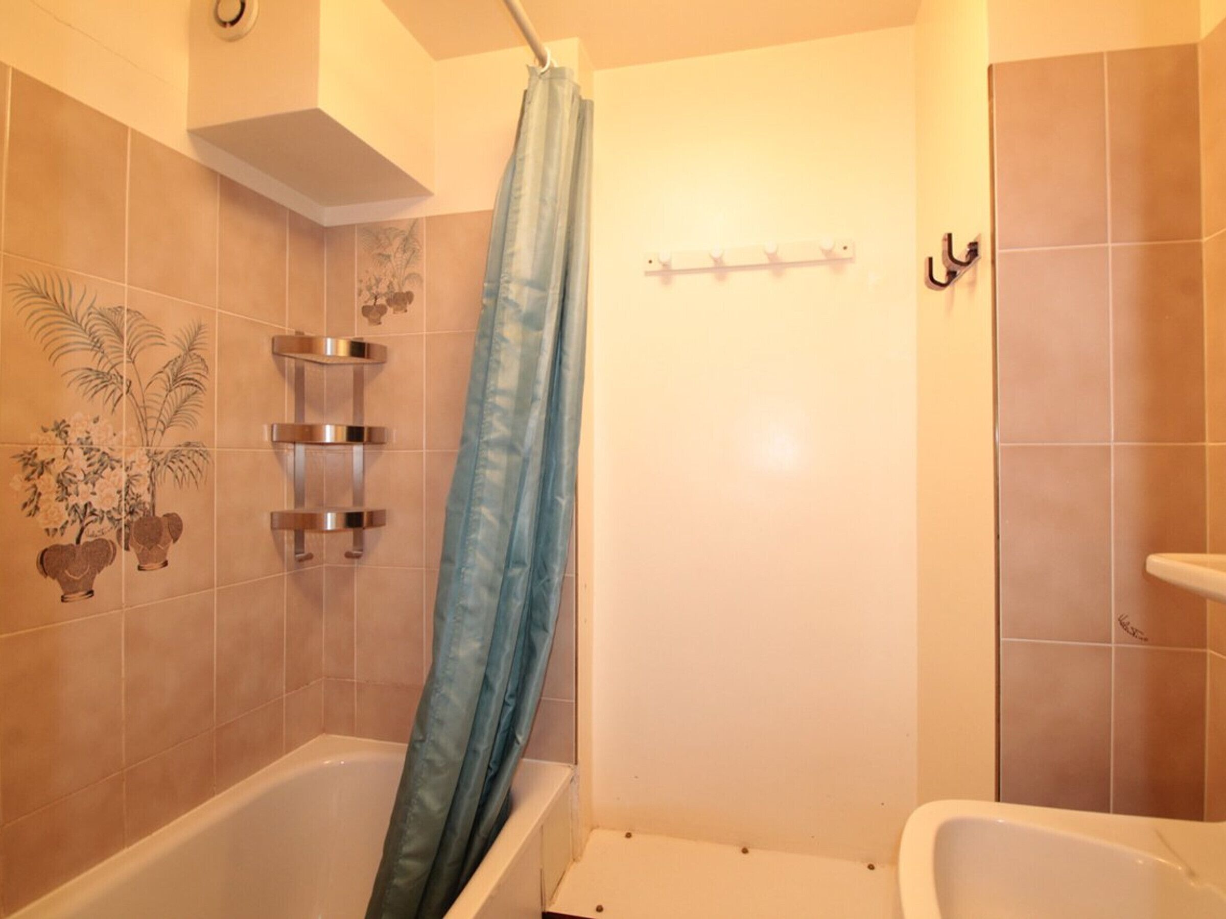 Une salle de bain avec une baignoire, un rideau de douche et des carreaux décoratifs.