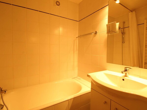 A bathroom with a bathtub, a sink, and a shower.