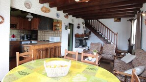 A cozy living room with a round table, wooden chairs, and a patterned tablecloth. A basket of lemons is on the table. - Cozy Chalet 6p, 2BR, Near Ski Lifts, Garage, South-West Terrace (Arâches-la-Frasse)