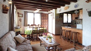 A cozy living room with a sofa, a wooden coffee table, and a dining area with a table and chairs. - Cozy Chalet 6p, 2BR, Near Ski Lifts, Garage, South-West Terrace (Arâches-la-Frasse)