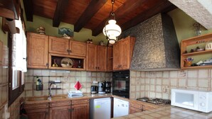 A kitchen with wooden cabinets, a tiled backsplash, a gas stove, a microwave, and a sink. - Cozy Chalet 6p, 2BR, Near Ski Lifts, Garage, South-West Terrace (Arâches-la-Frasse)