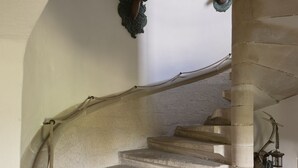 A stone staircase with antlers mounted on the wall, a rope handrail, and a lantern hanging from the ceiling. - Urlaub im Wasserschloss Irmelshausen (Höchheim)