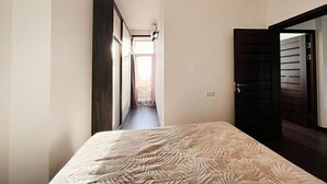 A narrow hallway leading to a bedroom with a bed. -  A rare minimalist concept in a quiet location with skyline view (Yerevan)
