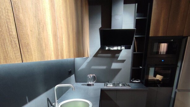 A compact kitchen with a modern design, featuring a sink, a stove, and a microwave. -  A rare minimalist concept in a quiet location with skyline view (Yerevan)