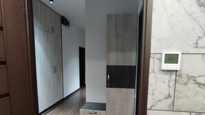 A modern bathroom with a marble wall, a wooden floor, and a built-in bench. -  A rare minimalist concept in a quiet location with skyline view (Yerevan)