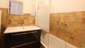 A bathroom with a sink, mirror, and shower. - Spacious studio 4 pers with garage and dishwasher in Les Carroz (Les Carroz d'Arâches)
