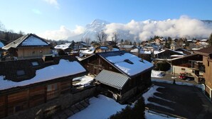A snow-covered village with traditional wooden houses, a clear sky, and a mountain in the background. - Spacious studio 4 pers with garage and dishwasher in Les Carroz (Les Carroz d'Arâches)