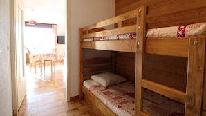 A bunk bed room with wooden walls and a tiled floor. - Spacious studio 4 pers with garage and dishwasher in Les Carroz (Les Carroz d'Arâches)