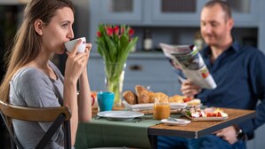 A breakfast setting with a table set for two, including croissants, a plate of fruit, and a cup of coffee. - Ferrata Guesthouse (Csesznek)