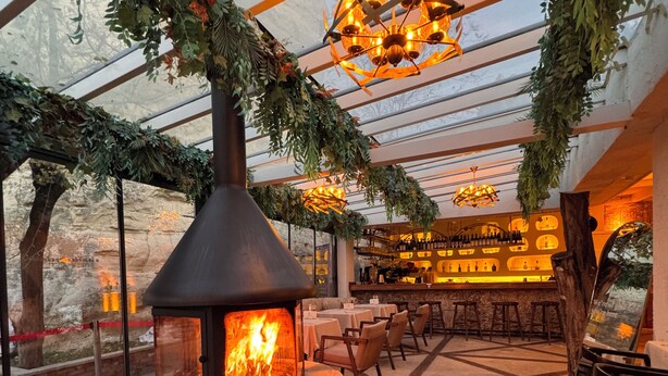 Un espace patio intérieur doté d’un poêle à bois, de sièges et d’un bar.