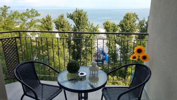 A balcony with two chairs, a small table, and a vase with sunflowers. - Bellavista (Marina Julia)