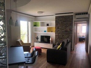 Una sala de estar con televisión, asientos y una pared de acento de piedra.