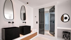 A modern bathroom with two black sinks, a large mirror, and a glass shower enclosure. - Psarou Black Villa II (Mykonos)