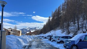 A snow-covered road with parked cars and buildings in the background. - STUDIO CENTER RESORT LA FOUX D'ALLOS SLEEPS 4 MOUNTAIN CHALET ATMOSPHERE (La Foux d’Allos)